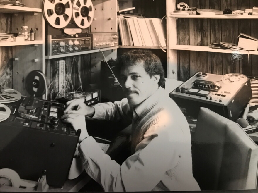 Man editing tape on reel-to-reel machine. 