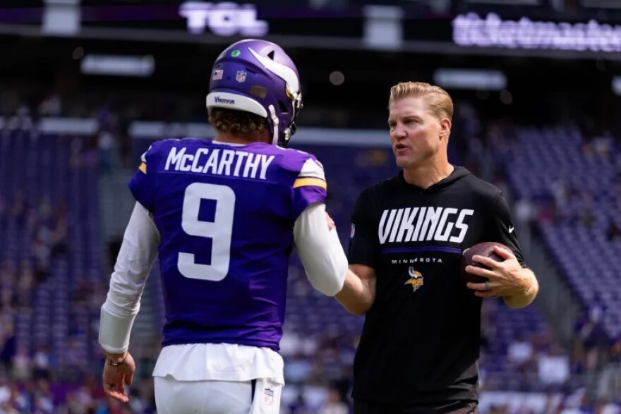 Minnesota Vikings quarterback J.J. McCarthy greets quarterbacks coach Josh McCown during an NFL preseason football game against the Baltimore Ravens on Aug. 22, 2026, in Minneapolis.
