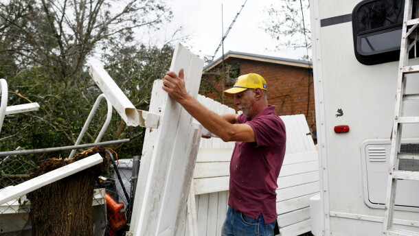 Curt Brown picks up debris left by Isaias around his RV home on Saturday, Oct. 10, 2026, in Milton, Fla. (AP Photo/Octavio Jones)