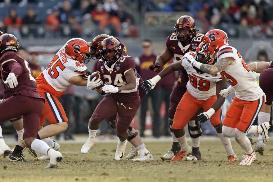 Minnesota running back Mohamed Ibrahim (24) runs past Syracuse defensive back Justin Barron (23) during the first half of the Pinstripe Bowl NCAA college football game Thursday, Dec. 29, 2022, in New York. (AP Photo/Adam Hunger)