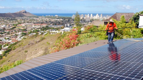 FILE - In this 2016 photo, an installer for RevoluSun works on a solar panel installation on a roof in Honolulu. (AP Photo/Cathy Bussewitz)