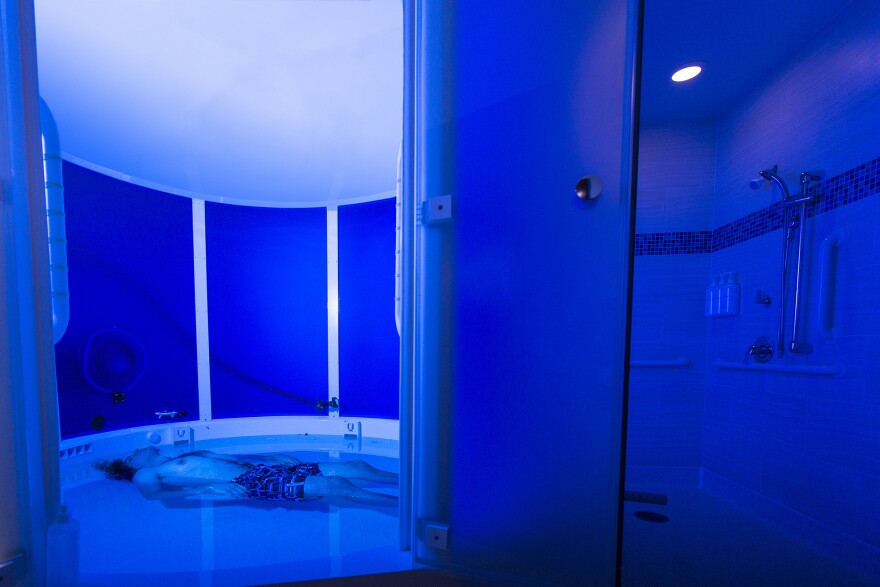 A staff member demonstrates the float tank used for studies at the Laureate Institute for Brain Research in Tulsa, Okla.