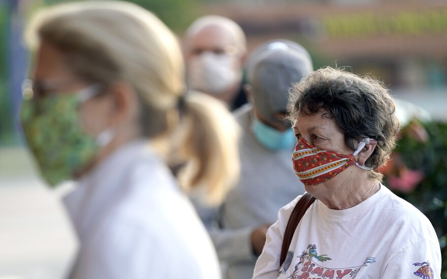 Shoppers wear face masks, to help prevent the spread of COVID-19, as they wait to enter a store Monday, April 27, 2020, in Houston. ==