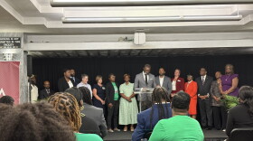 A crowd sits facing Birmingham Mayor Randall Woodfin and other city leaders at a press conference unveiling the city's 5-year strategic plan to reduce violence.