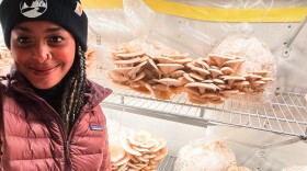 a woman in a jacket and hat stands near mushrooms