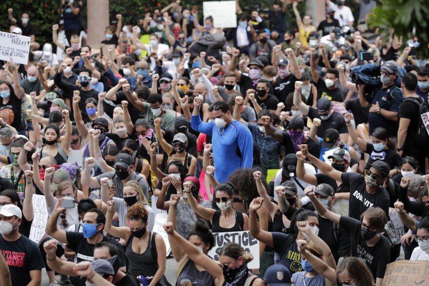 People raise their fists during a protest over the death of George Floyd, Saturday, June 6, 2020, in Miami. Protests continue over the death of Floyd, a black man who died while in police custody in Minneapolis. (AP Photo/Lynne Sladky)