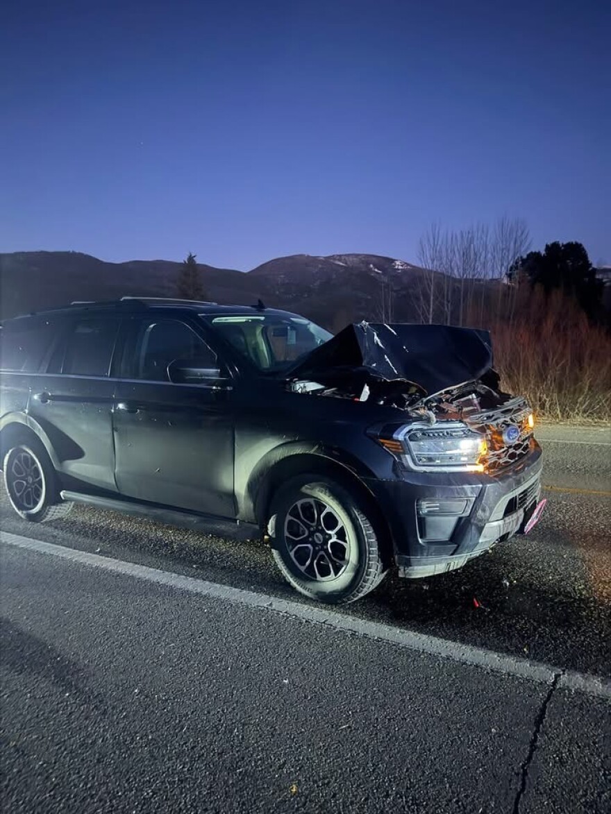 An SUV on a dark road with a smashed front end.