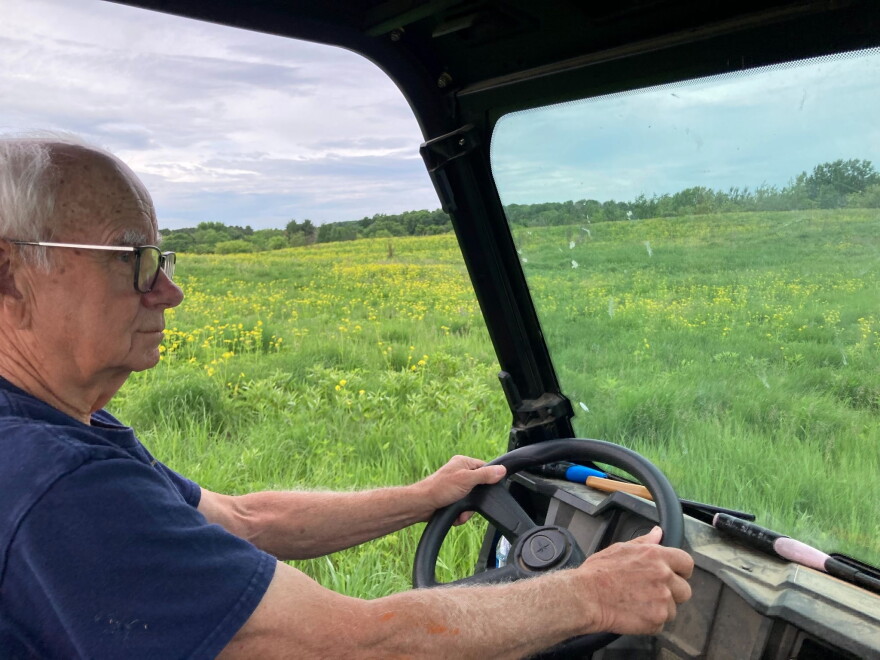 Dave Clausen drives his side-by-side across his land: hundreds of acres of prairie and woodlands that he’s been restoring since his retirement. (credit: Ellie Katz / Points North)