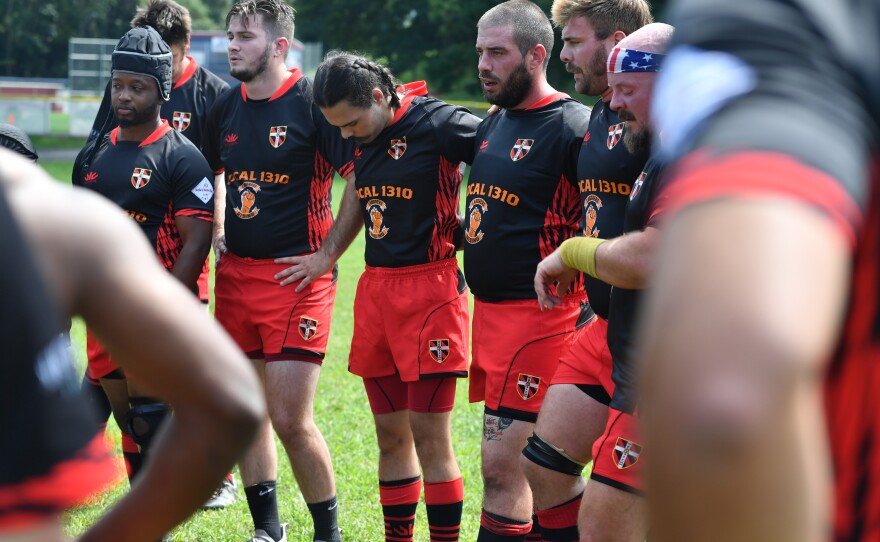 The WB Breaker Rugby team takes a break and listens to their coach.