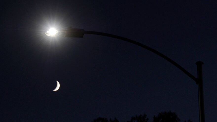 A waxing crescent moon is seen behind a streetlight with a newly installed LED fixture in 2011 in Las Vegas. The city was replacing 6,600 existing lights with the energy-efficient LEDs. It has since replaced tens of thousands more.