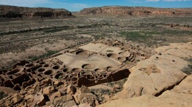 A hiker sits on a ledge above Pueblo Bonito, the largest archeological site at the Chaco Culture National Historical Park, in northwestern New Mexico, Aug. 28, 2021.