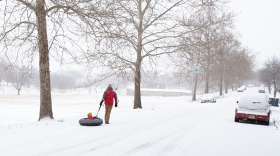A dad plays with his son in the snow at Gillham Park in Kansas City, Missouri, on Jan. 24, 2026.