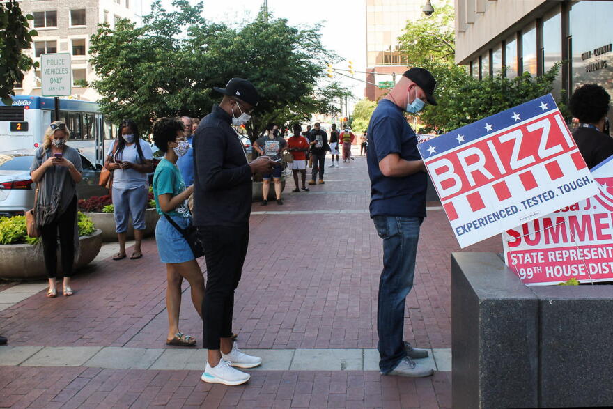 Indianapolis voters – many wearing masks – wait in line to vote at a polling place on Election Day.
