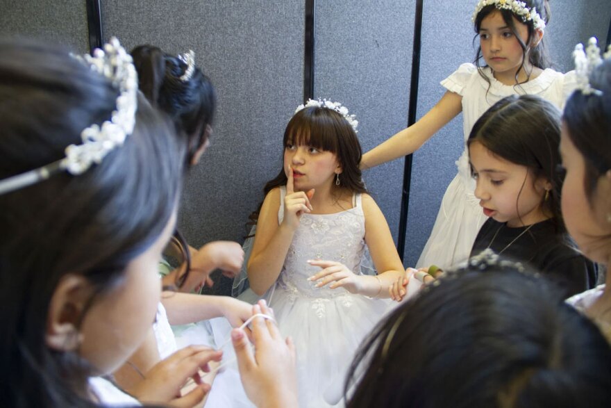 Left to right, Itzel Rodriguez, 9, Yasmin Ornales, 11, Zara Amante, 8 and other girls huddle before the fashion show for the Wenatchee Quinceañera Expo on March 7.