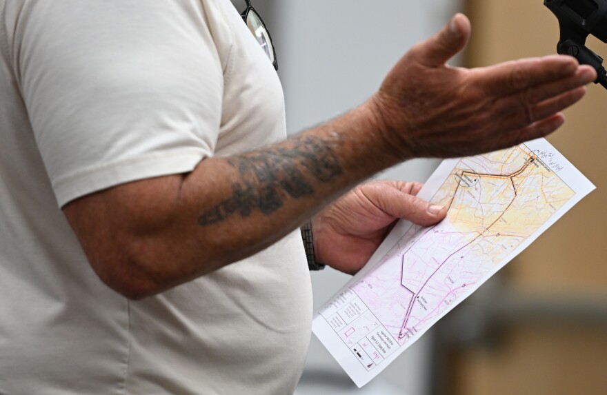 Lester Markle holds a map while testifying at Penn State Hazleton during a PUC hearing on PPL Electric Utilities' proposed transmission infrastructure upgrades project.