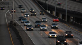 Vehicles travel on a roadway at night