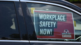 A sign in a car caravan at a labor rally in 2019 reads "Workplace Safety Now!"