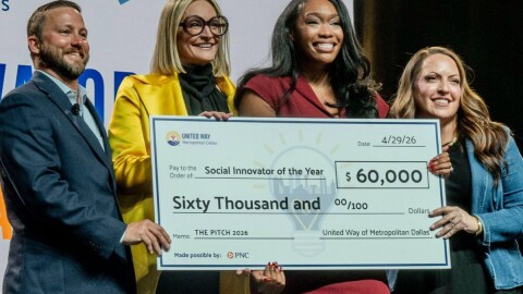 A photo of four people holding up a big novelty check for $60,000.