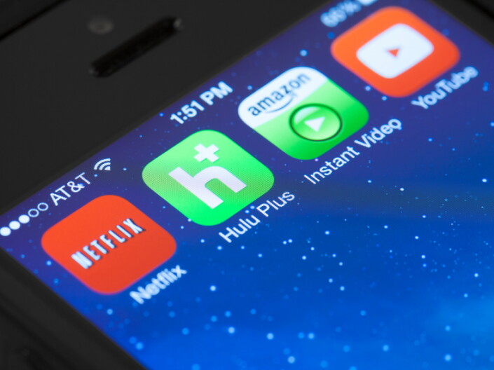 Streaming service apps are shown on a phone.
