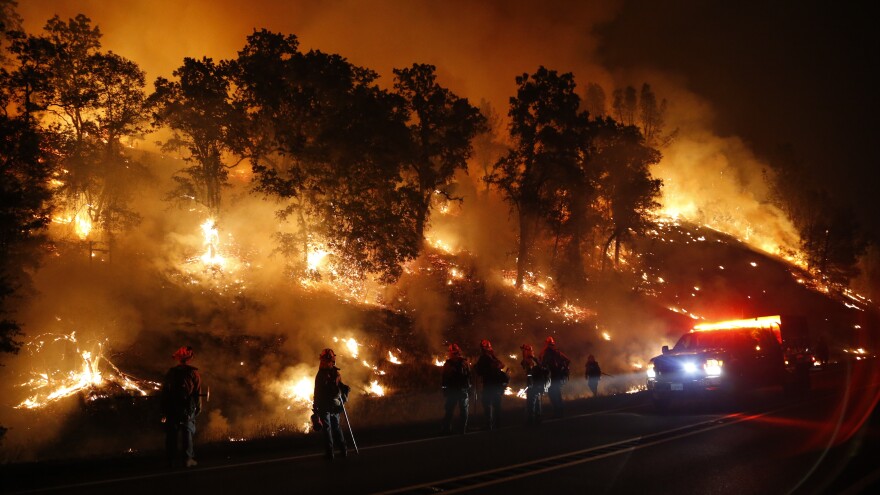 Firefighters monitor a backfire as they battle the Valley Fire on Sunday, near Middletown, Calif. The fast-moving fire has consumed 50,000 acres after growing 40,000 acres in 12 hours.