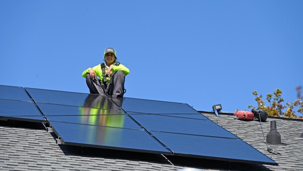 A RENU Energy Solutions installer puts panels on a roof in Davidson.