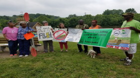 Members of CUFA hold signs demanding action in July following a sewage spill that closed Winton Lake.