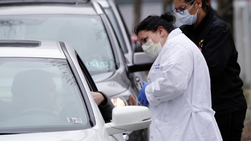 Cars line up outside the Central Outreach Wellness Center on the Northside of Pittsburgh Monday, March 16, 2020, for drive-by testing for COVID-19. 