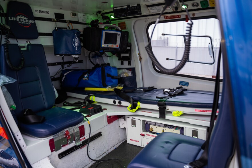 The inside of an air ambulance with blue seats and a stretcher.
