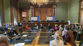 several people sit around a table in a room in the iowa capitol