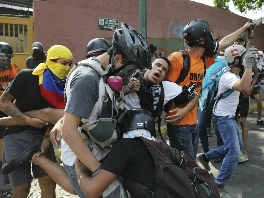 An anti-government protester is carried away after he was affected by tear gas launched by security forces, outside La Carlota airbase during clashes between the two sides in Caracas, Venezuela, on Wednesday.