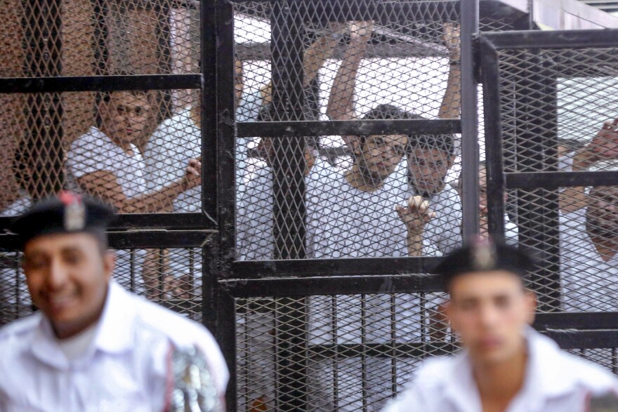 Elshamy (center) is seen inside the defendant's cage during a trial for him and other defendants in Cairo on May 15, 2014. Elshamy was held for 10 months in Egypt's Tora Prison and went on a hunger strike for 147 days before he was released in June 2014.