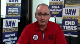 UAW president Shawn Fain wears a red shirt and looks into the camera during an online video update for the union's members. 