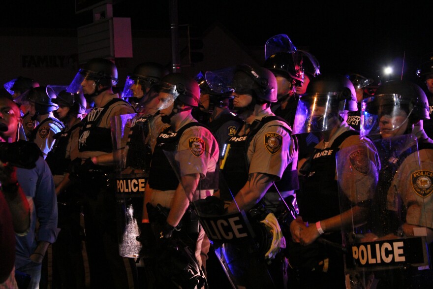 A line of police face off with protesters on West Florissant Ave., last Sunday night. 