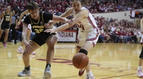 Purdue's Rickie Woltman (35) and Indiana's Mackenzie Holmes (54) battle for a loose ball during the first half of an NCAA college basketball game, Sunday, Feb. 19, 2023, in Bloomington, Indiana.