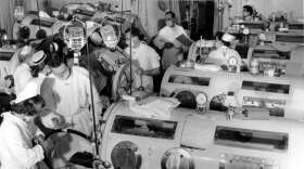 This is a scene in the emergency polio ward at Haynes Memorial Hospital in Boston, Ma., on Aug. 16, 1955. The city's polio epidemic hit a high of 480 cases. The critical patients are lined up close together in iron lung respirators so that a team of doctors and nurses can give fast emergency treatment as needed. (AP Photo)