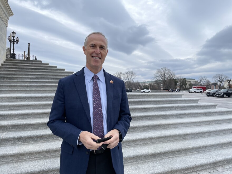 man in suit in front of marble stairs to Capitol