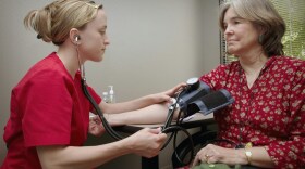 A healthcare worker taking a patient's blood pressure.
