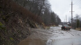 A truck drives by a mudslide