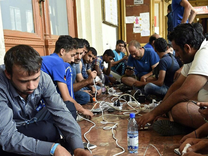 Migrants charge their cellphones at Keleti Railway Station in Budapest, Hungary, on Thursday.