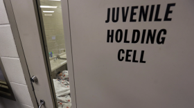 A door at a youth detention facility that reads Juvenile holding cell