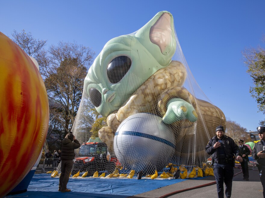 Police walk by an inflated helium balloon of Grogu, also known as Baby Yoda, from the Star Wars show The Mandalorian, Wednesday, Nov. 24, 2021, in New York, as the balloon is readied for the Macy's Thanksgiving Day Parade on Thursday. (AP Photo/Ted Shaffrey)