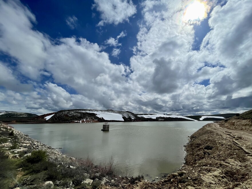 A large water reservoir under a partly cloudy sky.