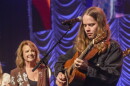 Billy Strings performs in the finale of the IBMA Awards, with singer Patty Loveless looking on.