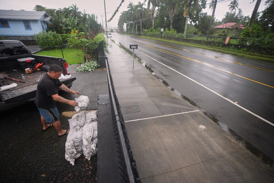 Louie Taasan places sand bags along his driveway as Hurricane Nolo sits nearby Friday, Sept. 25, 2026, in Hilo, Hawaii.