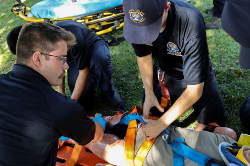 Cameron Loureiro, left, puts spider straps on a dummy patient who has lost limbs during an emergency call scenario.