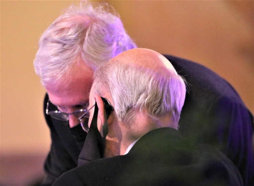 U.S. Senate Minority Leader Mitch McConnell shares a private word with former U.S. Kansas Sen. Pat Roberts as they wait for the Topeka memorial service to begin.