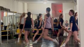 Irish dancers leaping in a circle as they practice for the upcoming parade