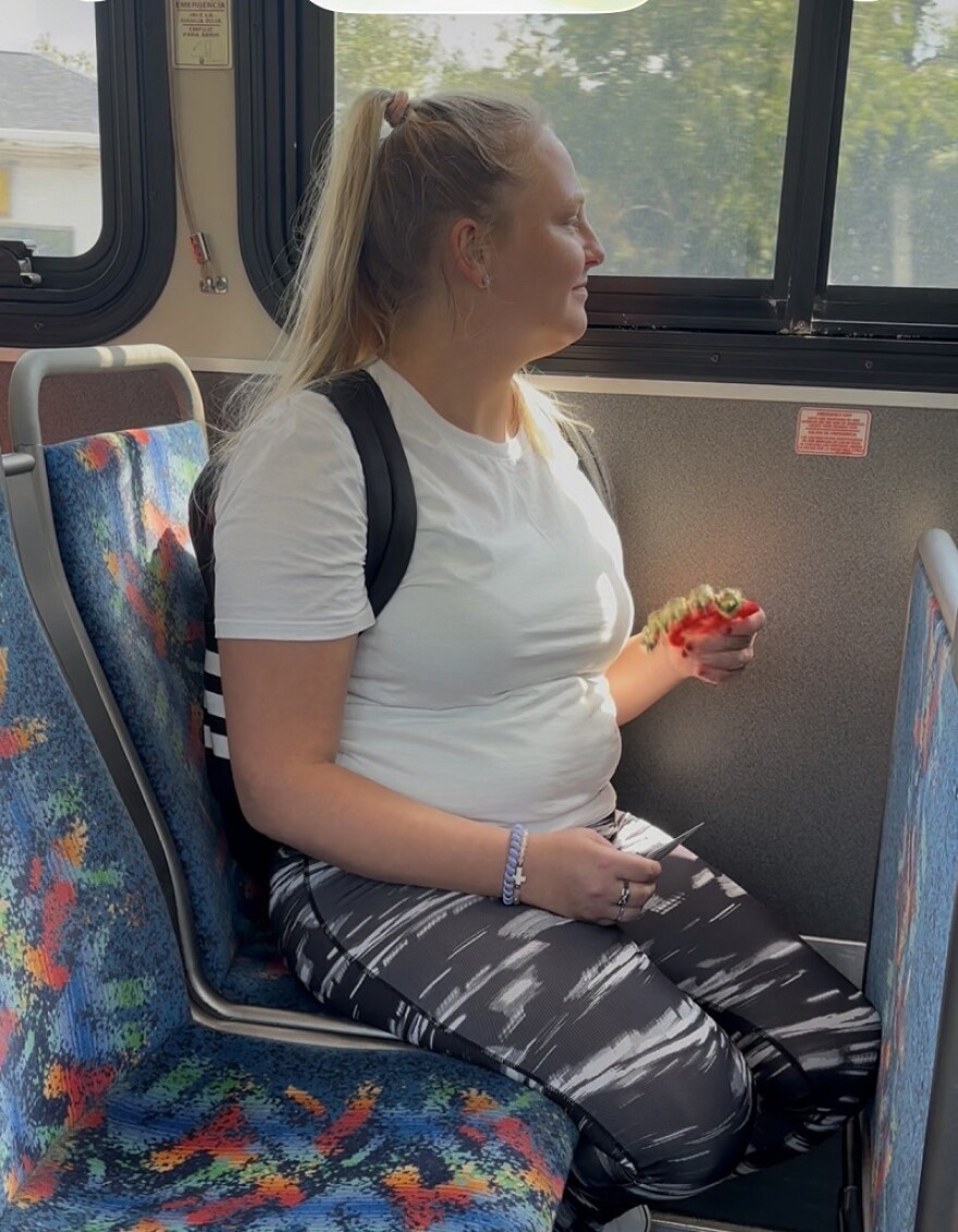 Bus rider Jaynee Whelan enjoys Ride with An Artist Day. She participates with a tiny tambourine she was given.