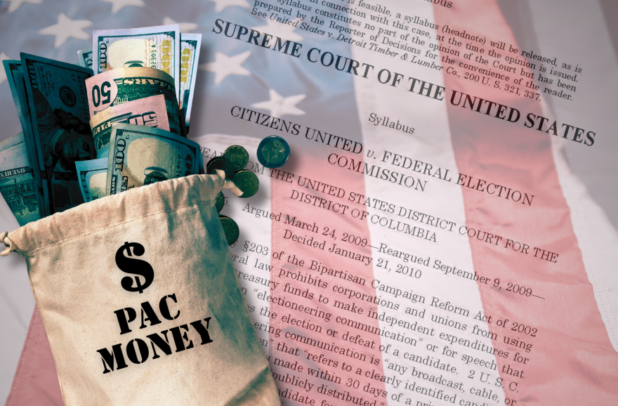 A brown sack of money sits on top of an American flag and a transparent copy of the Supreme Court decision on Citizens United vs. FEC. 