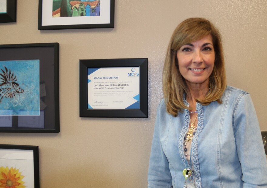 Lori Manresa, Hillcrest’s principal since 2008, smiles in front of her Principal of the Year honor on Tuesday, Feb. 17, 2026. After 36 years as an educator and 25 years at Hillcrest, she is retiring this year. “Just a beautiful way to end a career that I have loved since I started,” Manresa said. “I’m an advocate for kids. I will always be an advocate for kids. And I don’t know where my next journey takes me, but I have no doubt it’s going to have something to do with children.” (Amanda Roman/WUFT News)